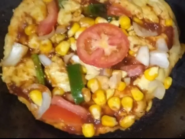 A homemade tawa-style pizza topped with vegetables, in the Mysore regional style.