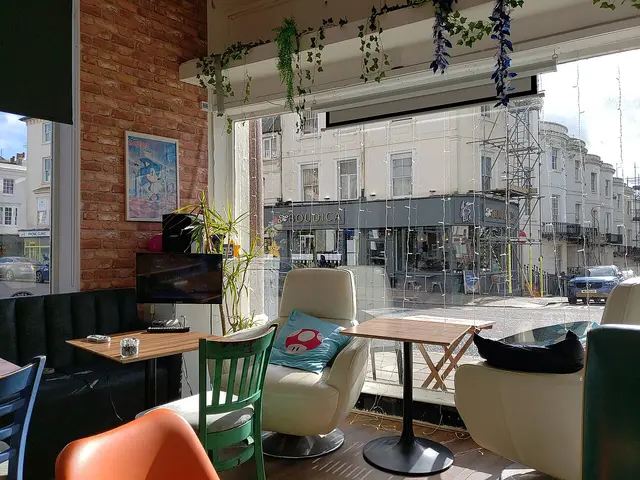 Interior of a cafe with tables equipped with monitors and gaming consoles.