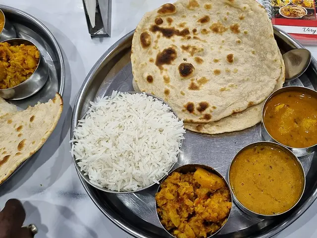An Indian plate with tandoori roti, rice, and mixed vegetable curry.