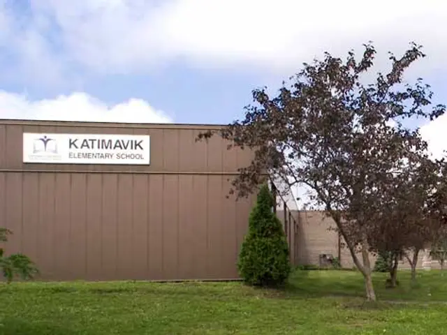 The exterior of Katimavik Elementary School, a low brick elementary school building with a sign by the entrance