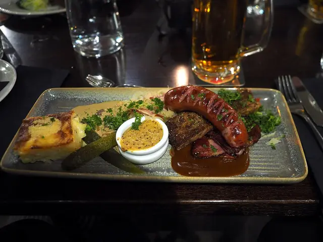 A plate of mixed grilled meats with side dishes served at a restaurant table.