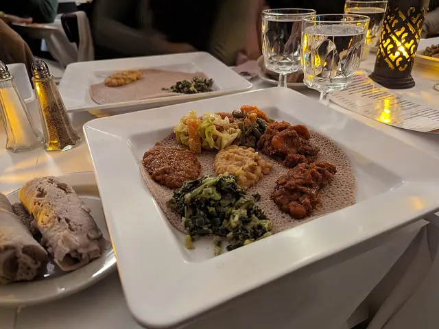 A vegetarian sampler platter of Ethiopian dishes served on injera flatbread at a restaurant.