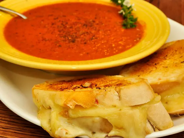 A grilled cheese sandwich served with roasted tomato soup.