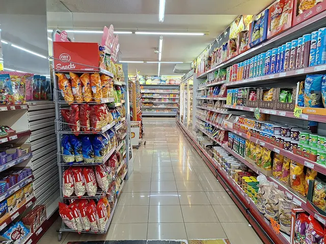 Interior aisle of a SPAR supermarket in Son Moro, Cala Millor, Mallorca, Spain, with tiled flooring and stocked shelves.