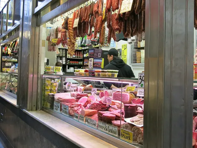 Butcher shop storefront with hanging signage inside the Queen Victoria Market in Melbourne, Australia.