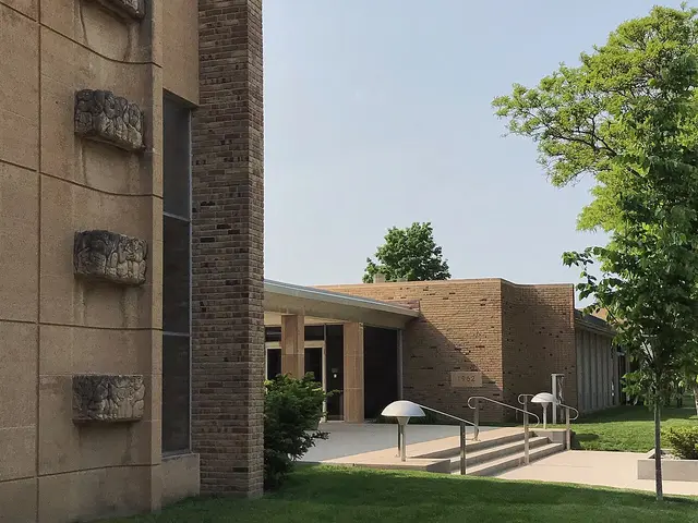 Modernist brick Christ Church Lutheran with carved stone relief panels and a slender bell tower in Minneapolis.