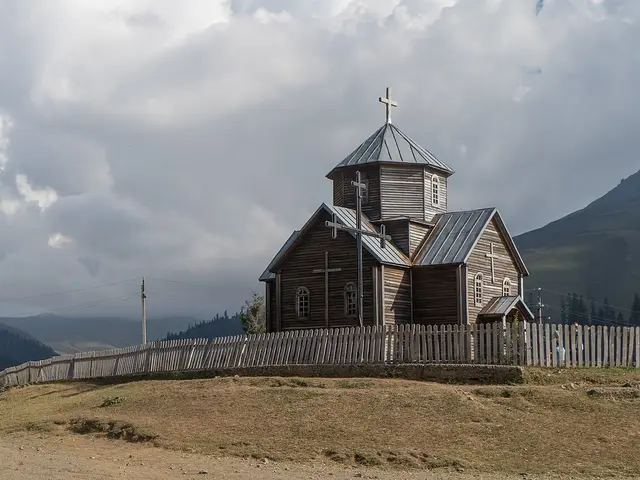 The exterior of a simple wooden church building surrounded by trees.