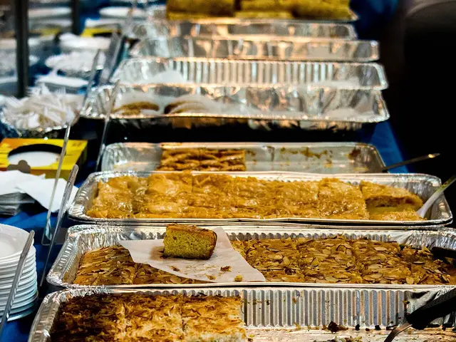 A row of assorted pastries in metal serving dishes.