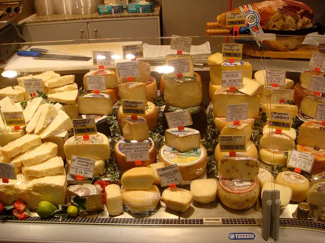 A cheese counter piled with wheels and wedges of Italian cheese inside a grocery store in Rome
