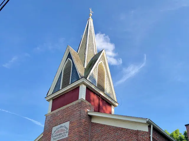 Exterior of First Evangelical Church of Christ, a brick building with a tall white steeple, in Aurora, Indiana.