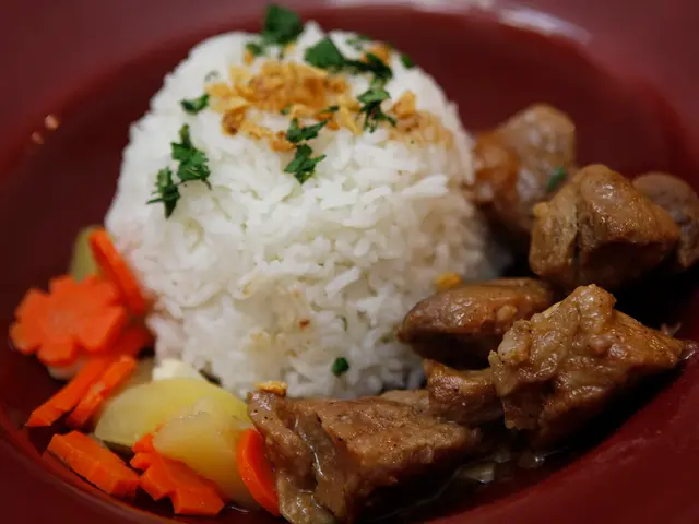 A plate of pork adobo served with garlic fried rice.