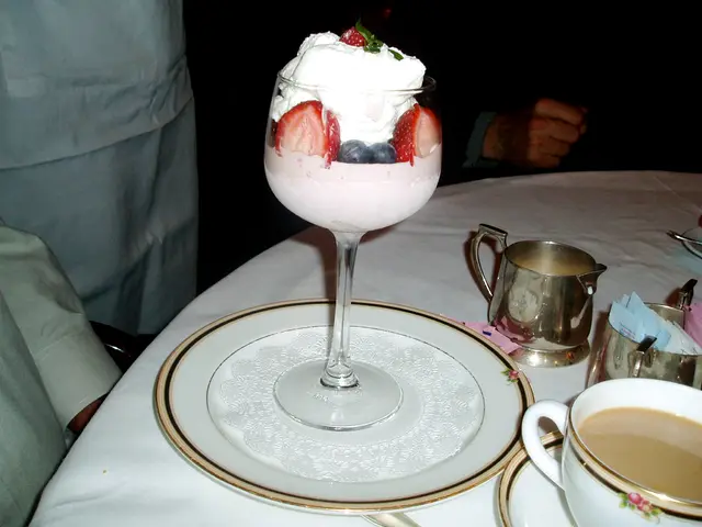 A fruit parfait dessert served on a plate at a restaurant.