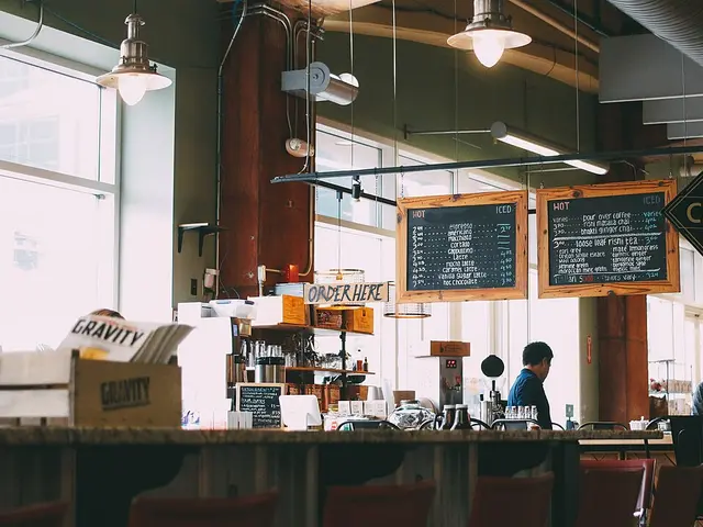 Two men standing at a coffee shop counter.