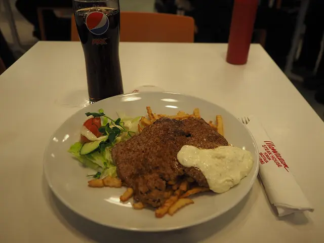 A minute steak with fries and salad served at a restaurant table.