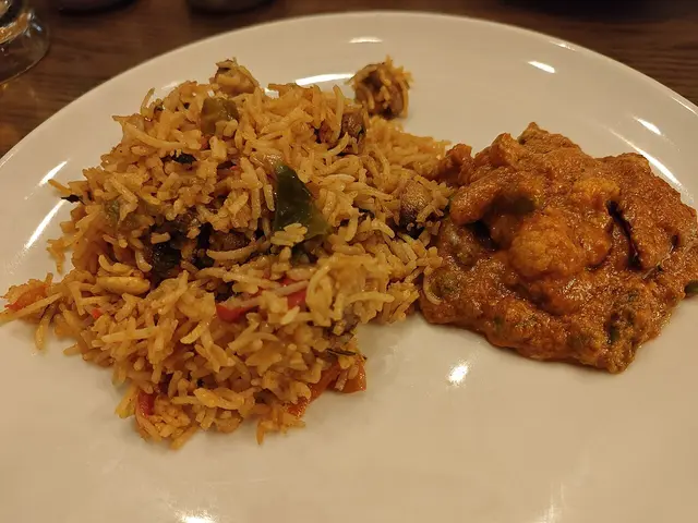 A plate of mushroom biryani and vegetable kolhapuri curry served at an Indian restaurant in Bangalore.