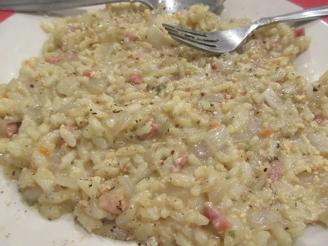 A plate of lemon risotto with ham and onion.