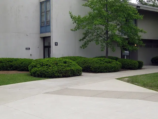 A 'School Entrance' sign and concrete facade at St. Therese Catholic School in Fort Wayne, Indiana.