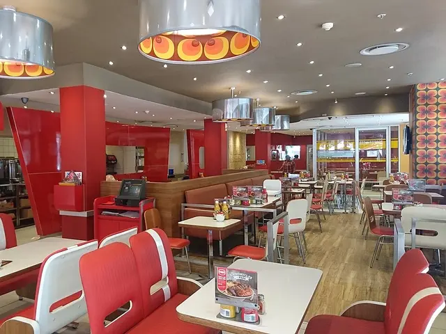 Interior dining area of a Wimpy restaurant in South Africa, with booths and tables in a diner-style layout.
