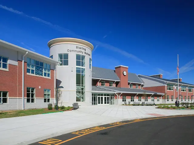 The modern brick and glass entrance tower of Sterling Community School, with the school's name above the doors.