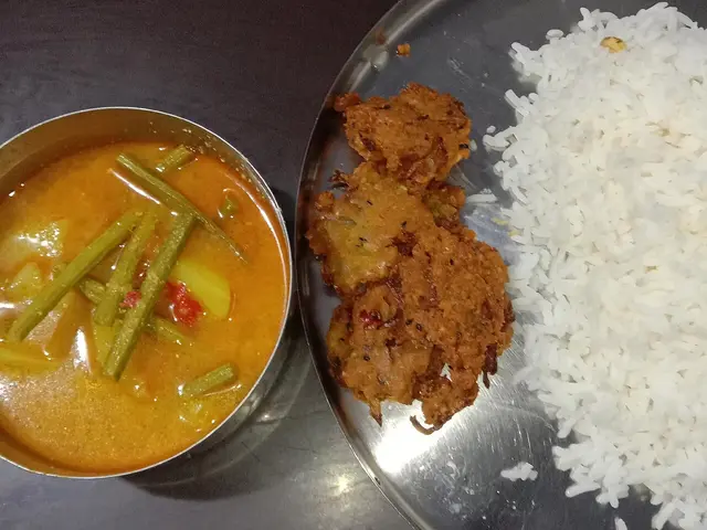 A Bengali Indian meal of rice served with drumstick curry and onion vada.