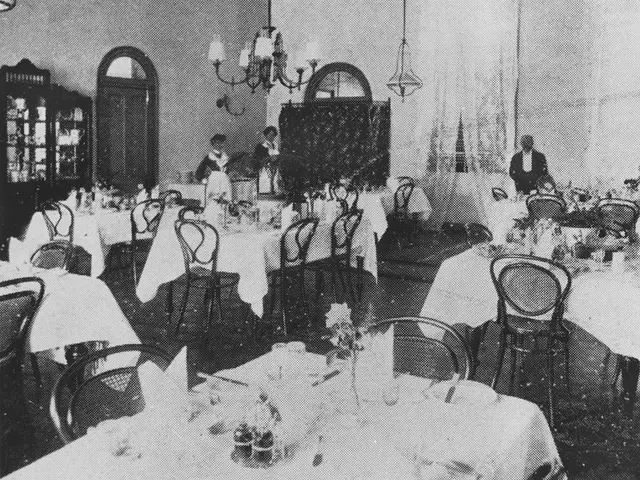 A 1907 photograph of a formal hotel dining room, with waiters and waitresses preparing for guests.