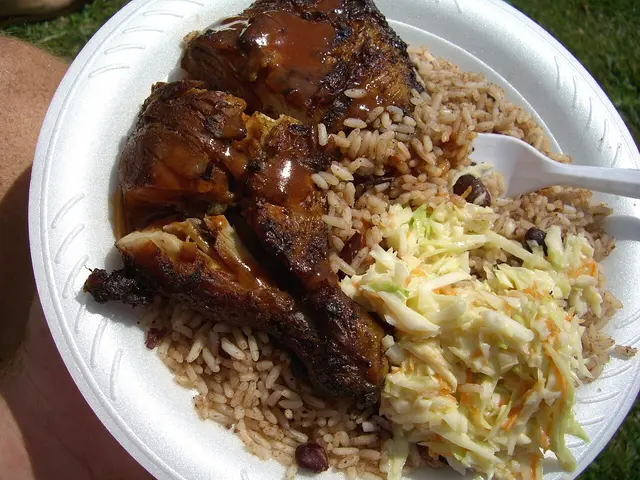 Jerk chicken served with rice and peas and coleslaw, a Caribbean dish.