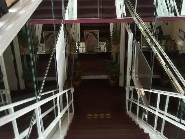 The interior stairwell and mirrored decor of an Indian restaurant.