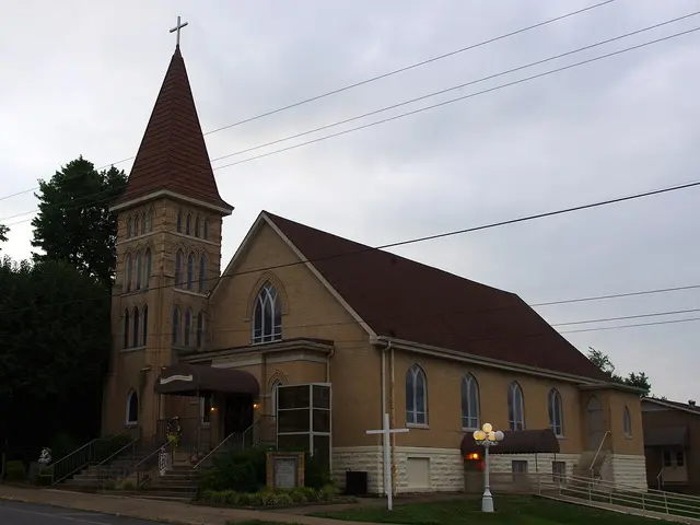 Exterior of Saint Joseph's Catholic Church in Central City, Kentucky, a brick church with a red-roofed bell tower at dusk.