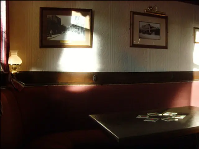 Interior of a public house showing wall seating lit by afternoon sun.