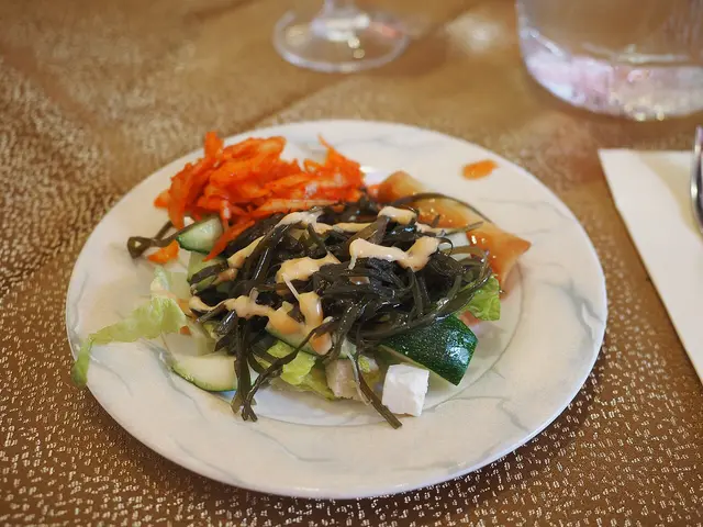 A plate of salad served as a starter at a restaurant table.