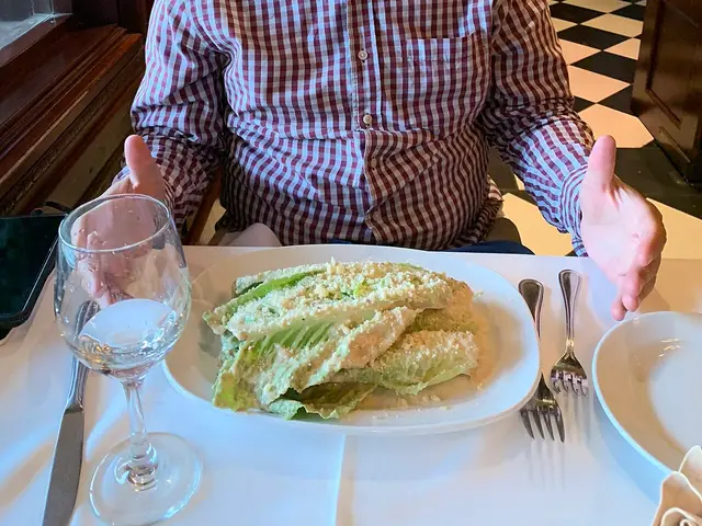 A plated Caesar salad served at a restaurant table.