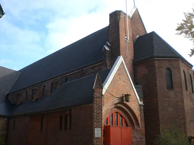 St Thomas Anglican Church of Canada in Toronto, a red brick church with an octagonal turret and steeply pitched slate roofs.