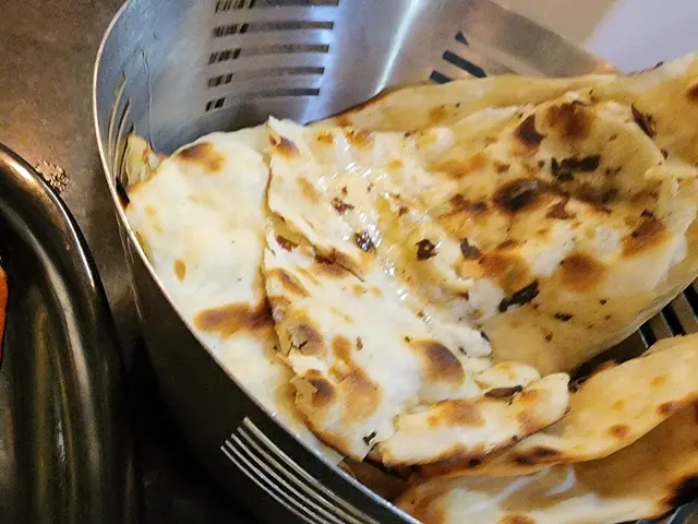Butter naan bread served alongside a bowl of butter chicken curry.