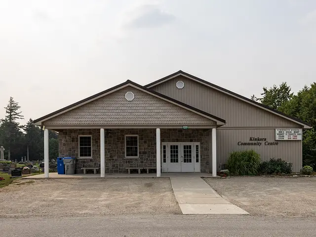The exterior of the Kinkora Community Centre, a single-storey stone and wood-sided community hall in Ontario