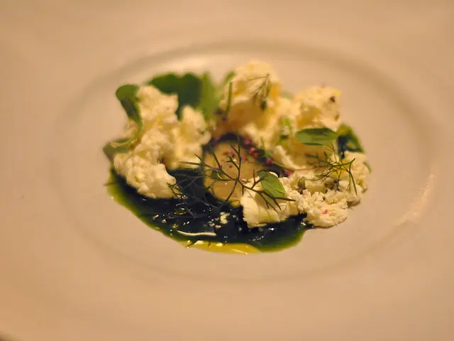A plated dessert with jelly and sauce served at a restaurant table.