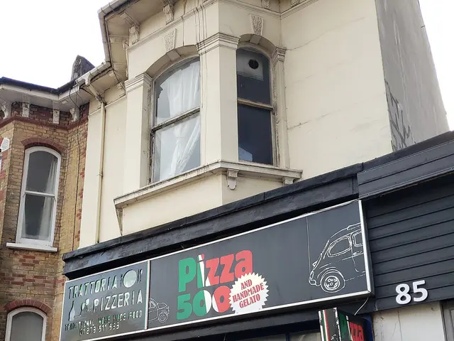 Storefront of an independent pizza takeaway shop.