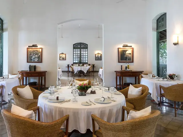 Restaurant dining room at the Amantaka resort and hotel in Luang Prabang, Laos, set with tables and chairs.