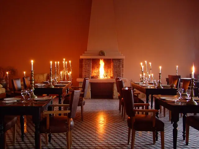 A candlelit restaurant dining room with tables set for guests.