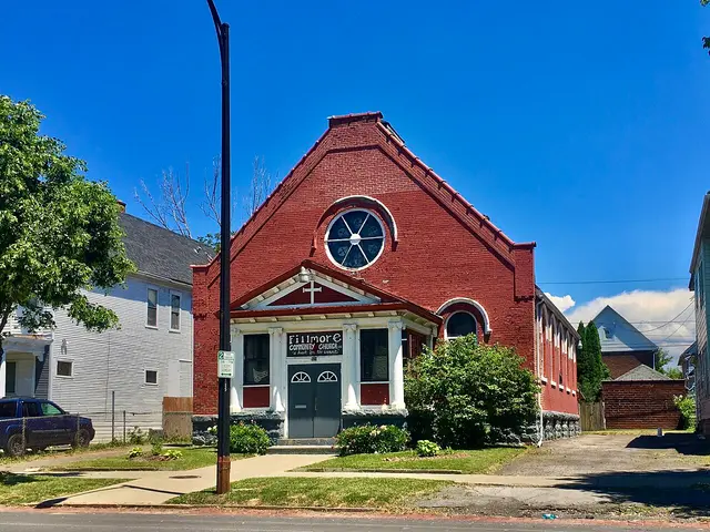 Exterior of Fillmore Community Church, a red brick building with a round window above the entrance, in Buffalo, New York.