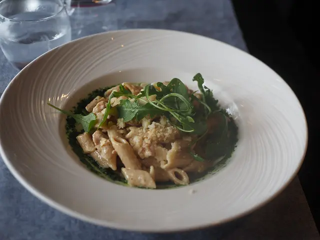 A plate of pasta carbonara served at a restaurant table.