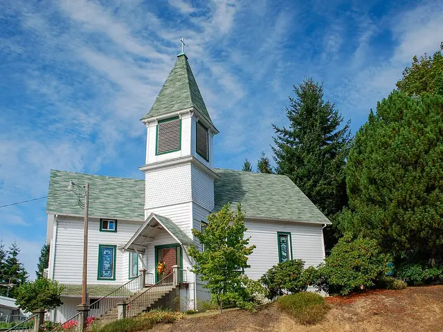 White wood-frame community church with a simple gabled entrance in Bellfountain, Oregon.
