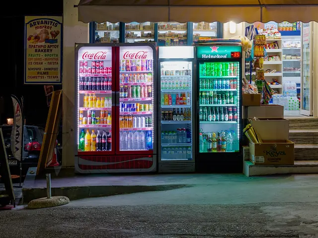 A supermarket exterior lit up at night on the Greek island of Santorini, with drink coolers visible through the windows