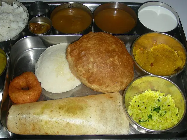 A South Indian thali dinner with rice and multiple curries on a plate.