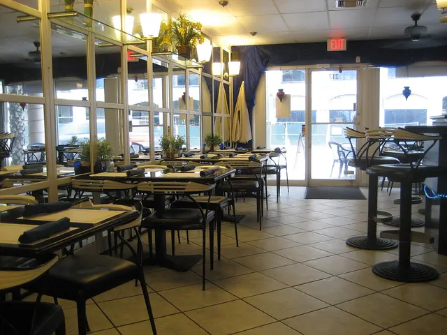 Interior dining area of an Indian restaurant with tables set for service.