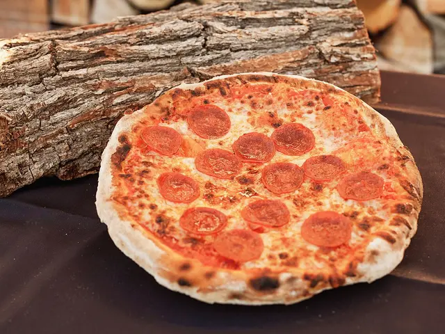 A pepperoni pizza cooking inside a wood-fired oven.
