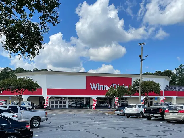 The red and white exterior of a Winn-Dixie grocery store and its parking lot in Georgia