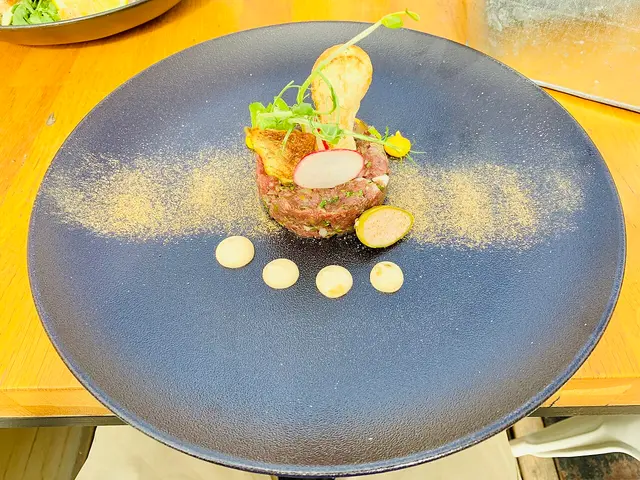 A plate of steak tartare served at a restaurant table.