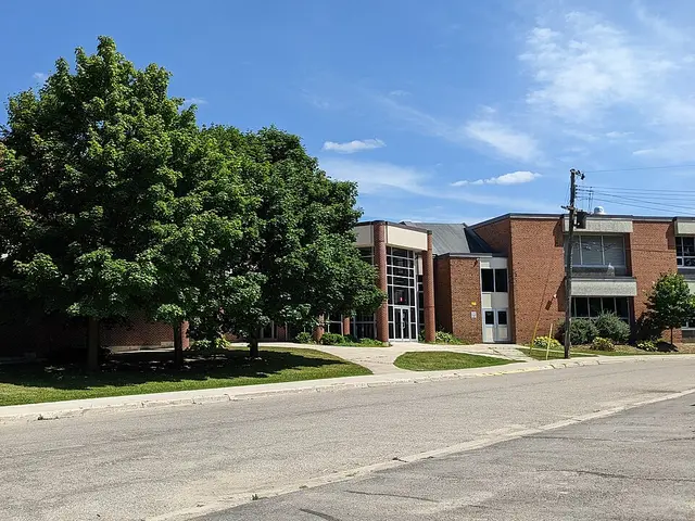 The brick entrance of Norwell District Secondary School, with a red sign bearing the school's name out front.