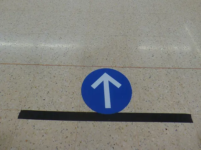 A supermarket aisle marked with one-way walking direction signs during the 2020 COVID-19 pandemic.