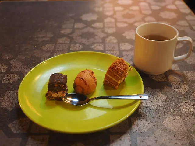 Small pastries served as dessert with a cup of coffee at a restaurant table.